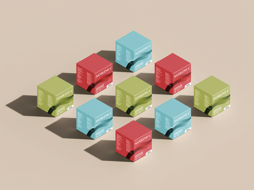 Nio färgglada produktförpackningar av Saniline C, placerade i ett rutmönster mot en beige bakgrund. Förpackningarna kommer i rött, grönt och blått och är märkta med texten 'Odour Protection' samt produktinformation.